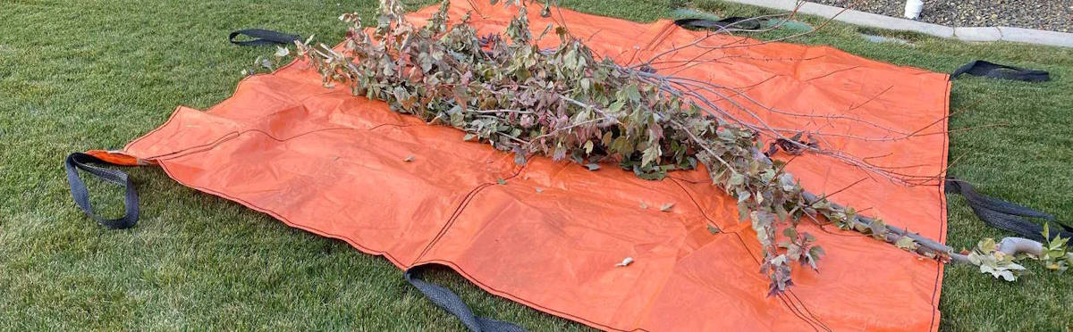 Outpak Sling Tarp with debris from lawn maintenance