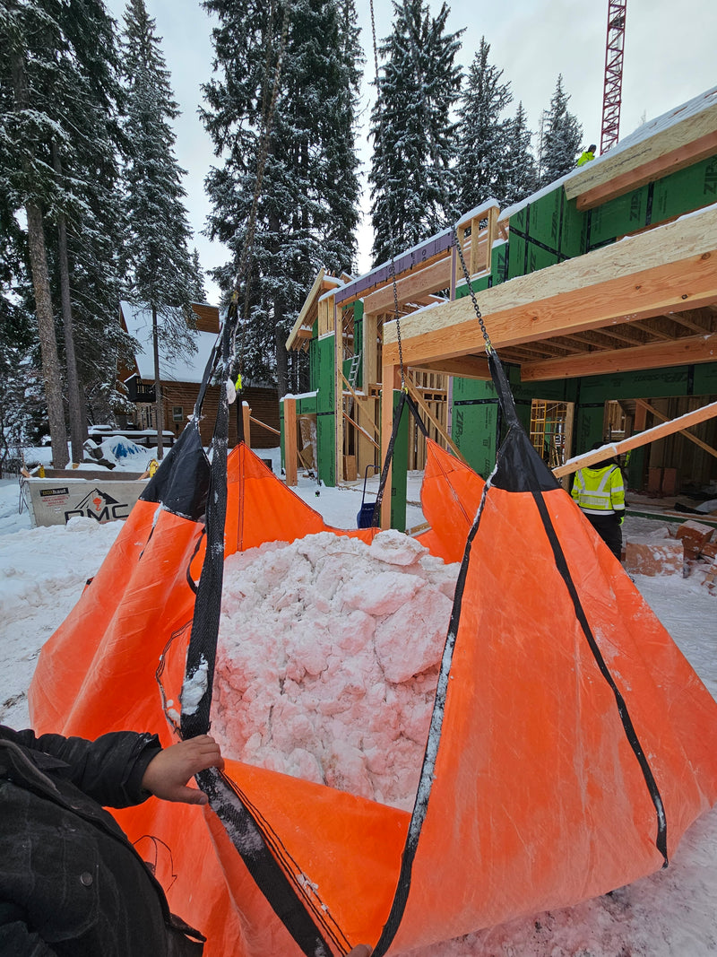 Outpak Debris Tarp clearing snow in a mountain lodge by crane.