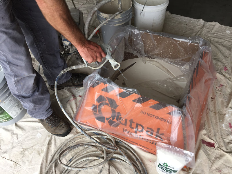 The Outpak paint washout being used to clean a paint sprayer.