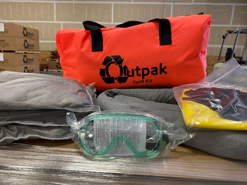 Outpak spill kit layed out on a table; easy to stow and can collect up to 25 gallons of oil or fuel.